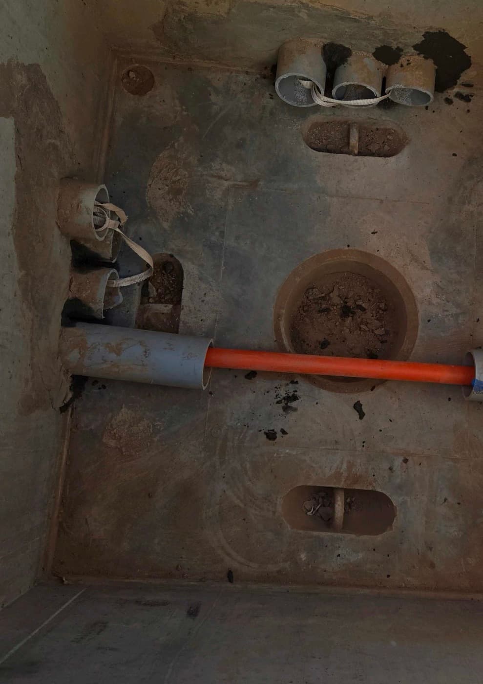 Inside a finished pullbox: conduit stubs and the ground, ready for wire