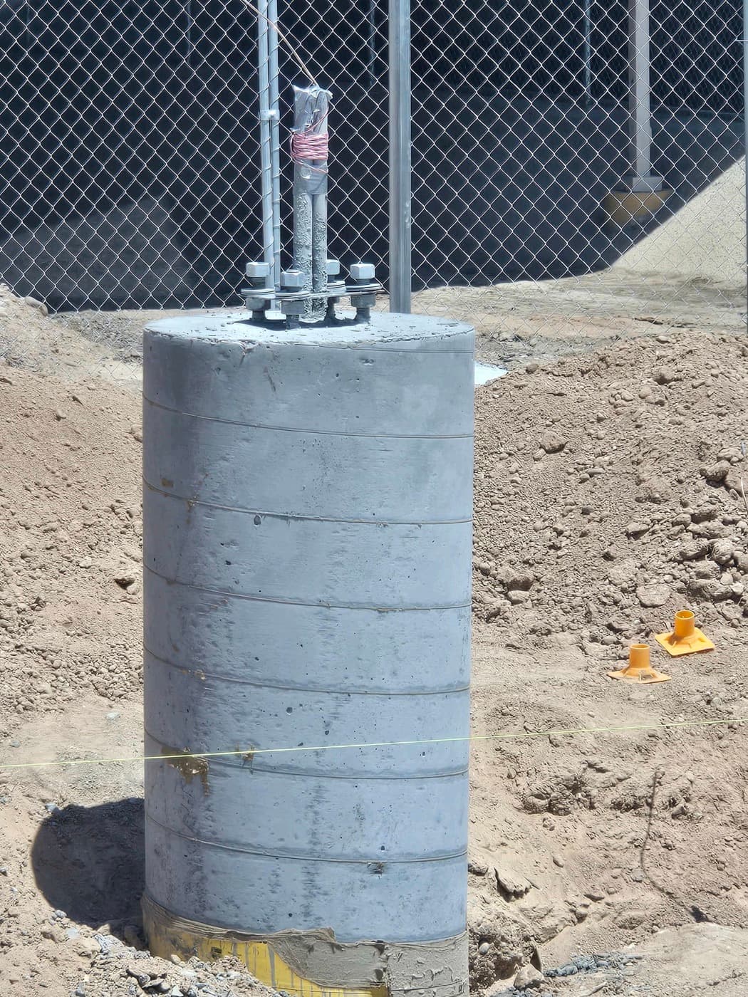 A finished light-pole foundation with anchor bolts and conduit