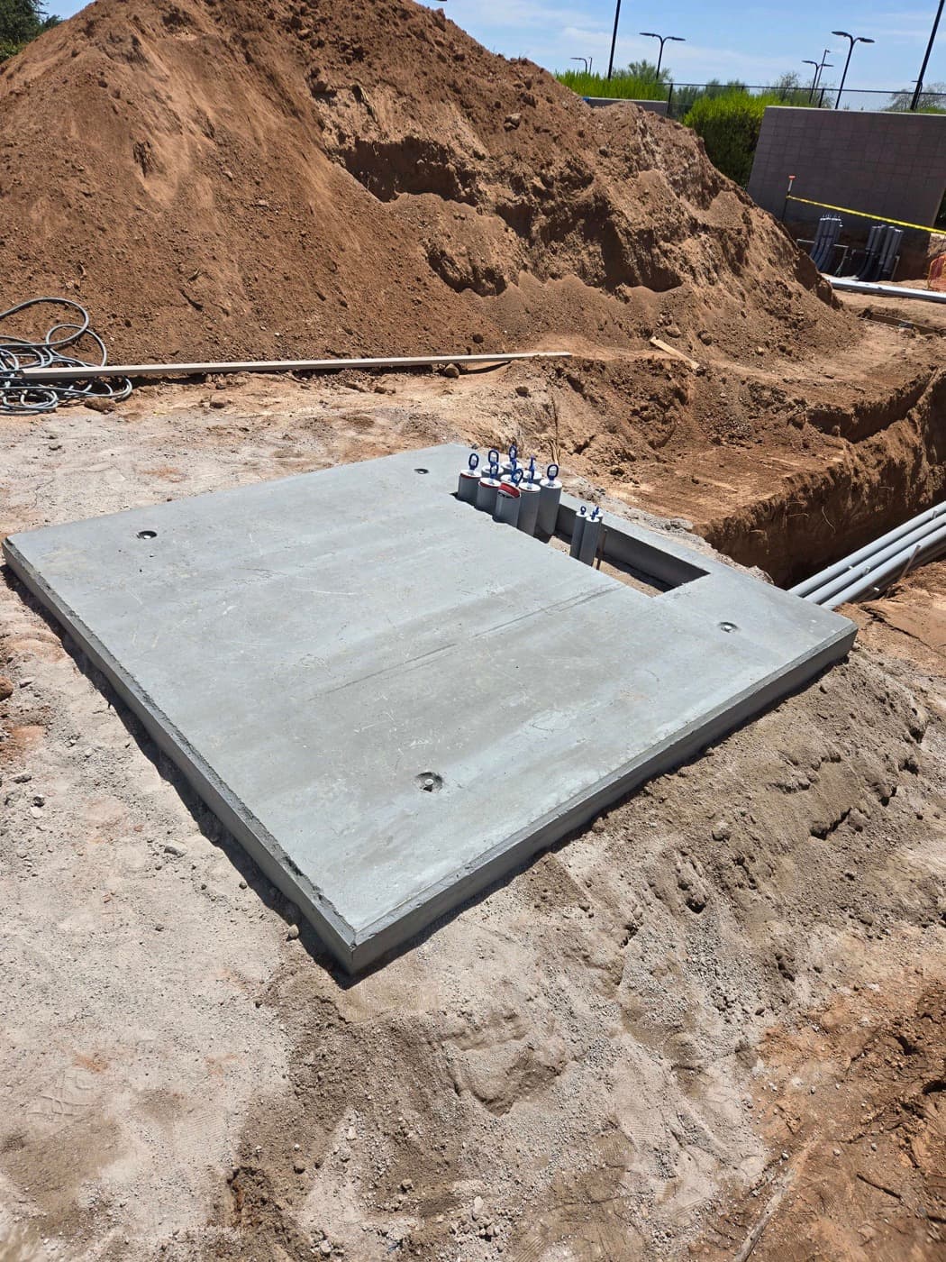A finished transformer pad with the conduit stubs coming up through it